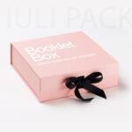 pink booklet box with black ribbon closure